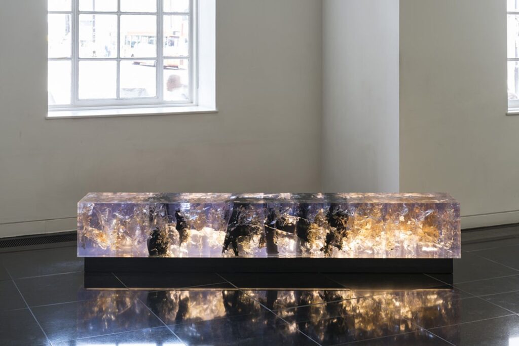Synthesis bench: sculpture bench by British artist Tom Price in the shape of a cuboid made of a mix of resin, tar and acrylic.